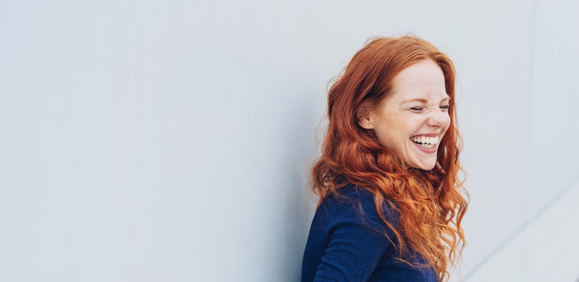 alone, attractive, background, building, casual, caucasian, curly, eyes shut, female, happy, lady, lifestyle, model, natural, one, outdoor, person, relaxed, sexy, urban, wall, white, 30s, confident, smile, leisure, emotional, excited, expression, joke, laugh